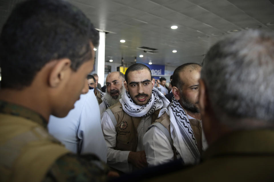 Yemeni prisoners gather during their arrival after being released by the Saudi-led coalition in the airport of Sanaa, Yemen, Thursday, Nov. 28, 2019. The International Committee of the Red Cross says over a hundred rebel prisoners released by the Saudi-led coalition have returned to Houthi-controlled territory in Yemen, a step toward a long-anticipated prisoner swap between the warring parties. (AP Photo/Hani Mohammed)