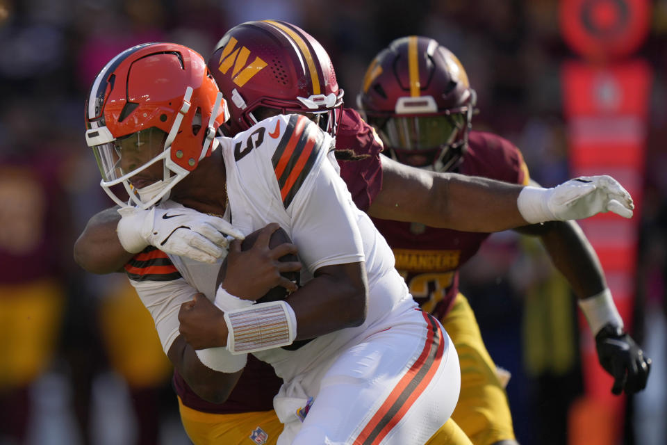 Cleveland Browns quarterback Jameis Winston, front is sacked by Washington Commanders quarterback Jayden Daniels, back, during the second half of an NFL football game in Landover, Md., Sunday, Oct. 6, 2024. (AP Photo/Stephanie Scarbrough)