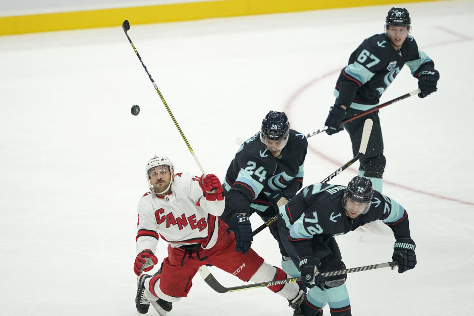 Carolina Hurricanes center Vincent Trocheck, left, works for the puck against Seattle Kraken defenseman Jamie Oleksiak (24) and right wing Joonas Donskoi (72) during the second period of an NHL hockey game Wednesday, Nov. 24, 2021, in Seattle. (AP Photo/Ted S. Warren)