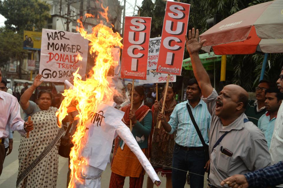 Activists of Socialist Unity Centre of India (Communist) shout slogans and burn an effigy of US President Donald Trump as they protest against his visit to India, in Siliguri February 24, 2020. - US President Donald Trump arrived in India on February 24 for a lightning visit featuring a huge rally at the world's biggest cricket stadium and other high-profile photo opportunities, but likely short on concrete achievements. (Photo by DIPTENDU DUTTA / AFP) (Photo by DIPTENDU DUTTA/AFP via Getty Images)