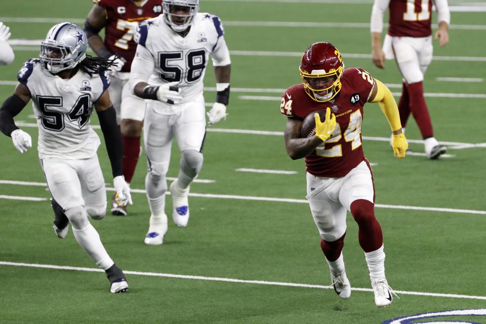 Washington Football Team running back Antonio Gibson sprints to the end zone for a touchdown after getting past Dallas Cowboys linebacker Jaylon Smith (54) and Aldon Smith (58) in the second half of an NFL football game in Arlington, Texas, Thursday, Nov. 26, 2020. (AP Photo/Roger Steinman)