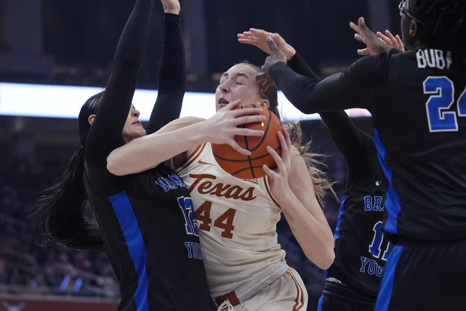 Texas forward Taylor Jones (44) is fouled as she drives to the basket against BYU forward Lauren Gustin, left, during the second half of an NCAA college basketball game in Austin, Texas, Saturday, March 2, 2024. (AP Photo/Eric Gay)