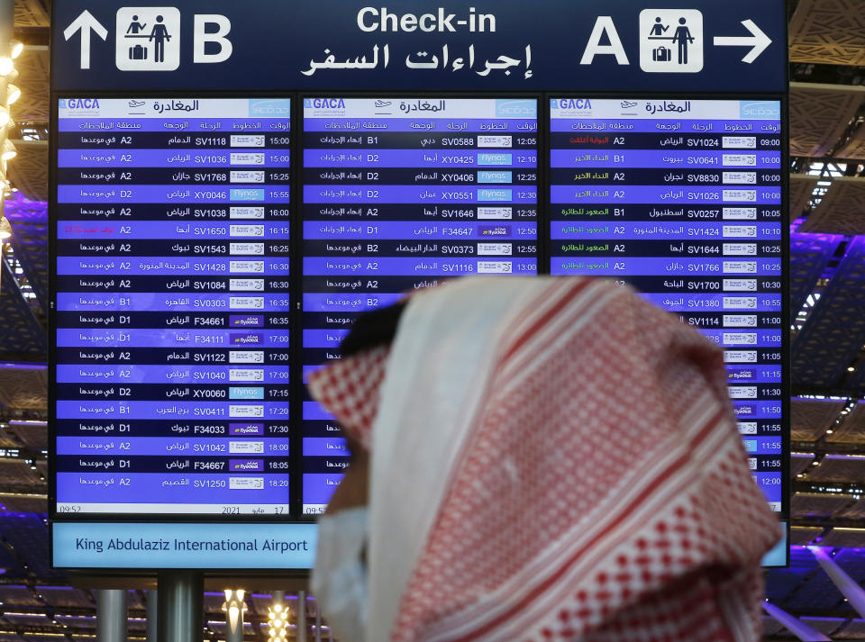 A screen displays local and international departures at King Abdulaziz International Airport in Jiddah, Saudi Arabia, Monday, May 17, 2021. Vaccinated Saudis will be allowed to leave the kingdom for the first time in more than a year as the country eases a ban on international travel that had been in place to try and contain the spread of the coronavirus and its new variants. (AP Photo/Amr Nabil)