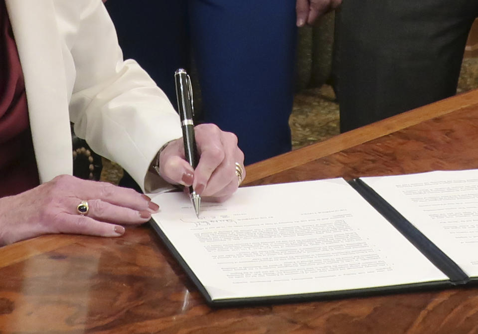 Kansas Gov. Laura Kelly signs an executive order aimed at ending an economic "border war" between her state and Missouri over jobs in the Kansas City area, Friday, Aug. 2, 2019, at the Statehouse in Topeka, Kansas. The states are promising not to use their incentives to lure existing businesses across their border in the area but the issue of local government incentives has not been fully resolved. (AP Photo/John Hanna)