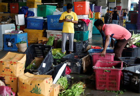 A stall keeper takes stock of vegetables at a wet market in Malaysia's southern city of Johor Bahru April 26, 2017. REUTERS/Edgar Su