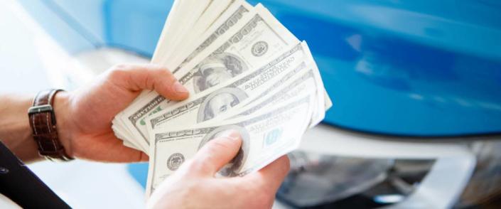 Holding cash in front of car