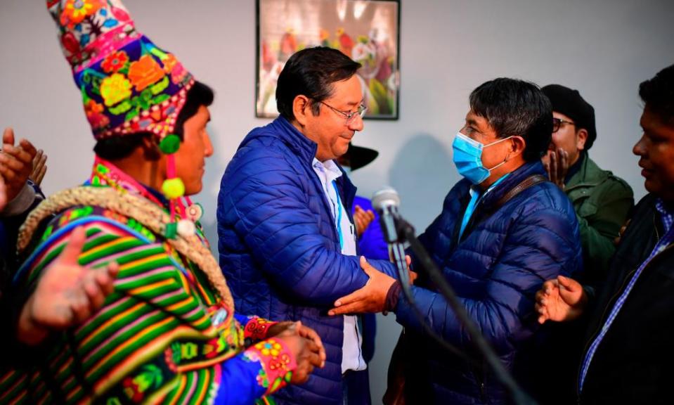 Luis Arce, centre, celebrates with running mate David Choquehuanca, right, in La Paz, Bolivia, on 19 October.