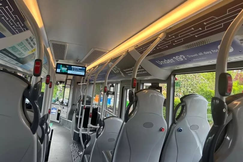 Interior of 39 Blue Line bus, with seats visible either side of main gangway and LED screen at front