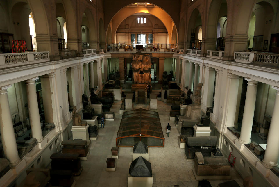 In this Wednesday, Oct. 30, 2013 photo, visitors look at antiquities inside the Egyptian Museum near Tahrir Square in Cairo, Egypt. The 111-year-old museum, a treasure trove of pharaonic antiquities, has long been one of the centerpieces of tourism to Egypt. But the constant instability since the 2011 uprising that toppled autocrat Hosni Mubarak has dried up tourism to the country, slashing a key source of revenue. Moreover, political backbiting and attempts to stop corruption have had a knock-on effect of bringing a de facto ban on sending antiquities on tours to museums abroad, cutting off what was once a major source of funding for the museum. (AP Photo/Nariman El-Mofty)