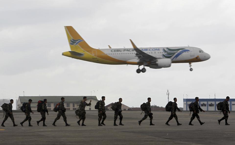 Members of Philippine Army prepare to board a US C-130 plane at Villamor Air Base