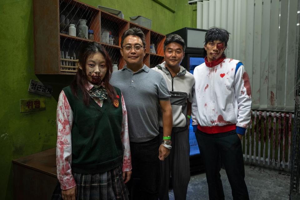 Producer Charles Park and Director JQ Lee of Netflix’s global hit zombie series 'All of Us Are Dead' with scare actors at the haunted house at Universal Studios Singapore Halloween Horror Nights 11. (Photo: Resorts World Sentosa)