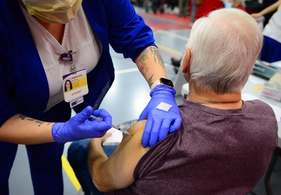 Bill King of Neshannock gets a Pfizer vaccine from Katherine McKenzie of Mercer, a UPMC Jameson nursing student.