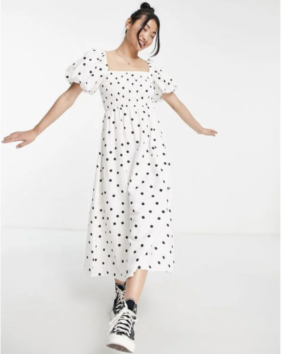 model in black sneakers and white black dress, New Look short sleeve shirred midi dress in white polka dot (Photo via ASOS)