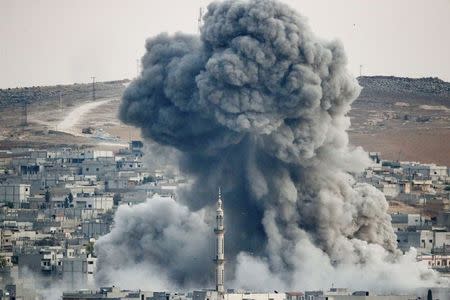 Smoke rises over Syrian town of Kobani after an airstrike, as seen from the Mursitpinar border crossing on the Turkish-Syrian border in the southeastern town of Suruc in Sanliurfa province, October 18, 2014. REUTERS/Kai Pfaffenbach