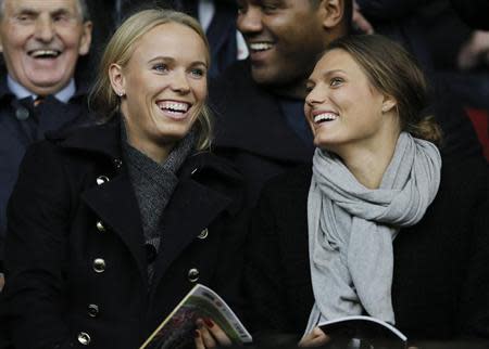 Danish tennis player Caroline Wozniacki (L) smiles as she takes her seat before the English Premier League soccer match between Liverpool and West Bromwich Albion at Anfield in Liverpool, northern England October 26, 2013. REUTERS/Phil Noble