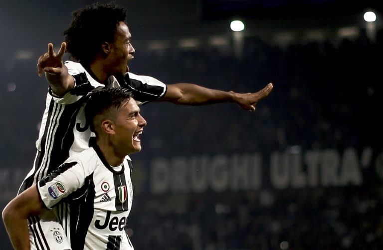 Juventus' forward Paulo Dybala (down) celebrates with Juan Cuadrado after scoring against Udinese on October 15, 2016