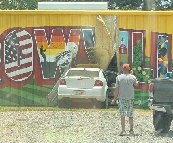 The newly painted mural on the side of the town's fire station was damaged when a car ran into the building Friday.