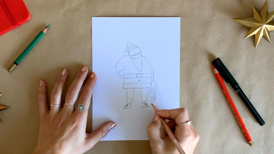 hands of illustrator finishing a drawing of santa