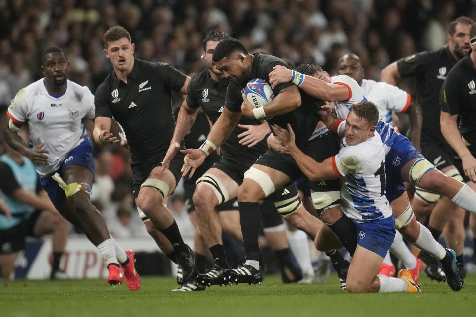 New Zealand's Ardie Savea, centre, challenges during the Rugby World Cup Pool A match between New Zealand and Namibia at the Stadium de Toulouse in Toulouse, France, Friday, Sept. 15, 2023. (AP Photo/Christophe Ena)