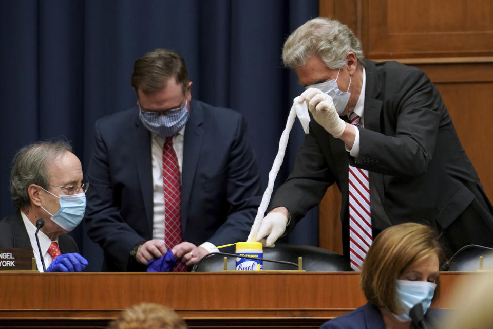 Rep. Eliot Engel, D-N.Y., and Rep. Frank Pallone, D-N.J., prepare to clean their seats before a House Energy and Commerce Subcommittee on Health hearing Thursday, May 14, 2020, on Capitol Hill in Washington. (Greg Nash/Pool via AP)