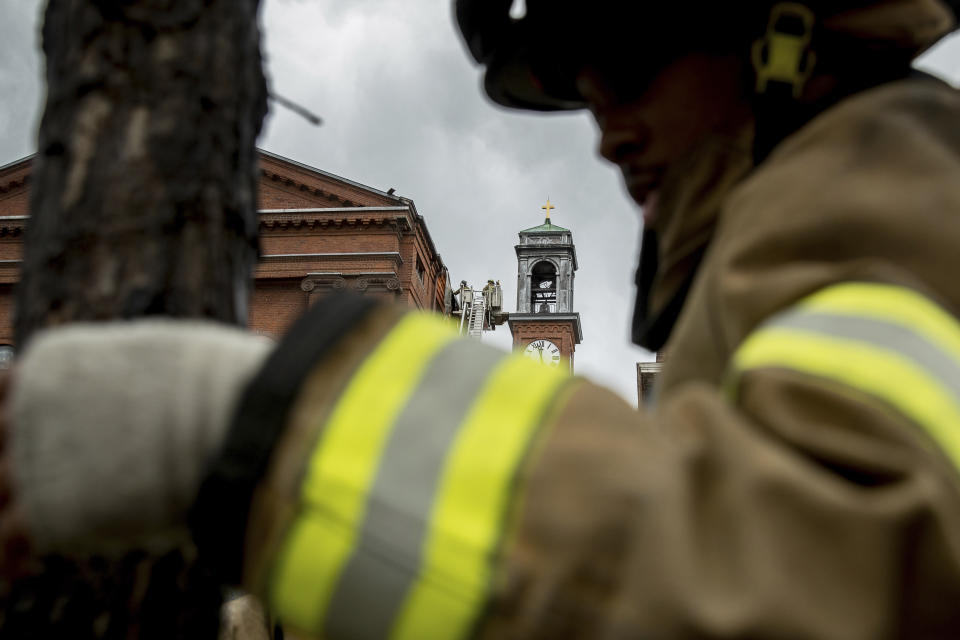 Firefighters work to cut pieces of damaged tin roof down after high winds damaged the roof of St. Aloysius Catholic Church at Gonzaga High School in Washington, Thursday, April 6, 2017. Buildings in the Washington area were damaged as rough weather moved through. (AP Photo/Andrew Harnik)