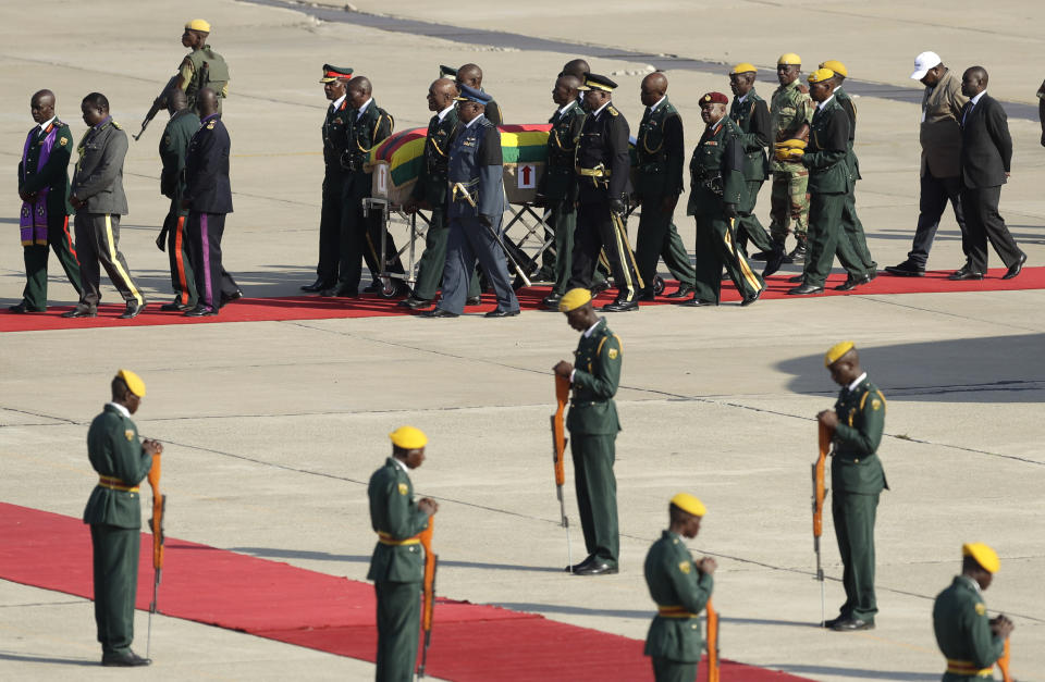 A coffin carrying the remains of Zimbabwe's longtime ruler Robert Mugabe arrives from Singapore, at the RG Mugabe International Airport in Harare, Wednesday Sept. 11, 2019. The body of Mugabe was flown to the capital, Harare, on Wednesday where it will be displayed at historic locations for several days before burial at a location still undecided because of friction between the ex-leader's family and the government. (AP Photo/Themba Hadebe)