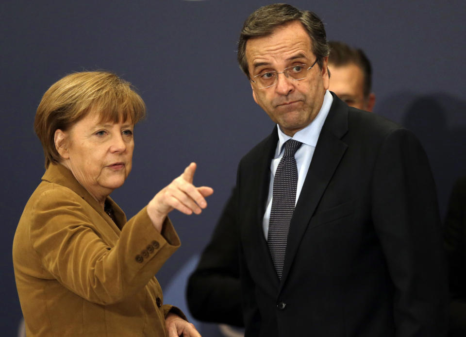 Greece's Prime Minister Antonis Samaras, right, listens to German Chancellor Angela Merkel before a meeting with young Greek businessmen in Athens on Friday, April 11, 2014. Merkel arrived for a brief visit, a day after the crisis-hit country returned to international bond markets. Greece this week reached a milestone in the recovery from its financial crisis — it successfully tapped bond markets for the first time since 2010, raising 3 billion euros ($4.14 billion) in five-year debt. (AP Photo/Thanassis Stavrakis)