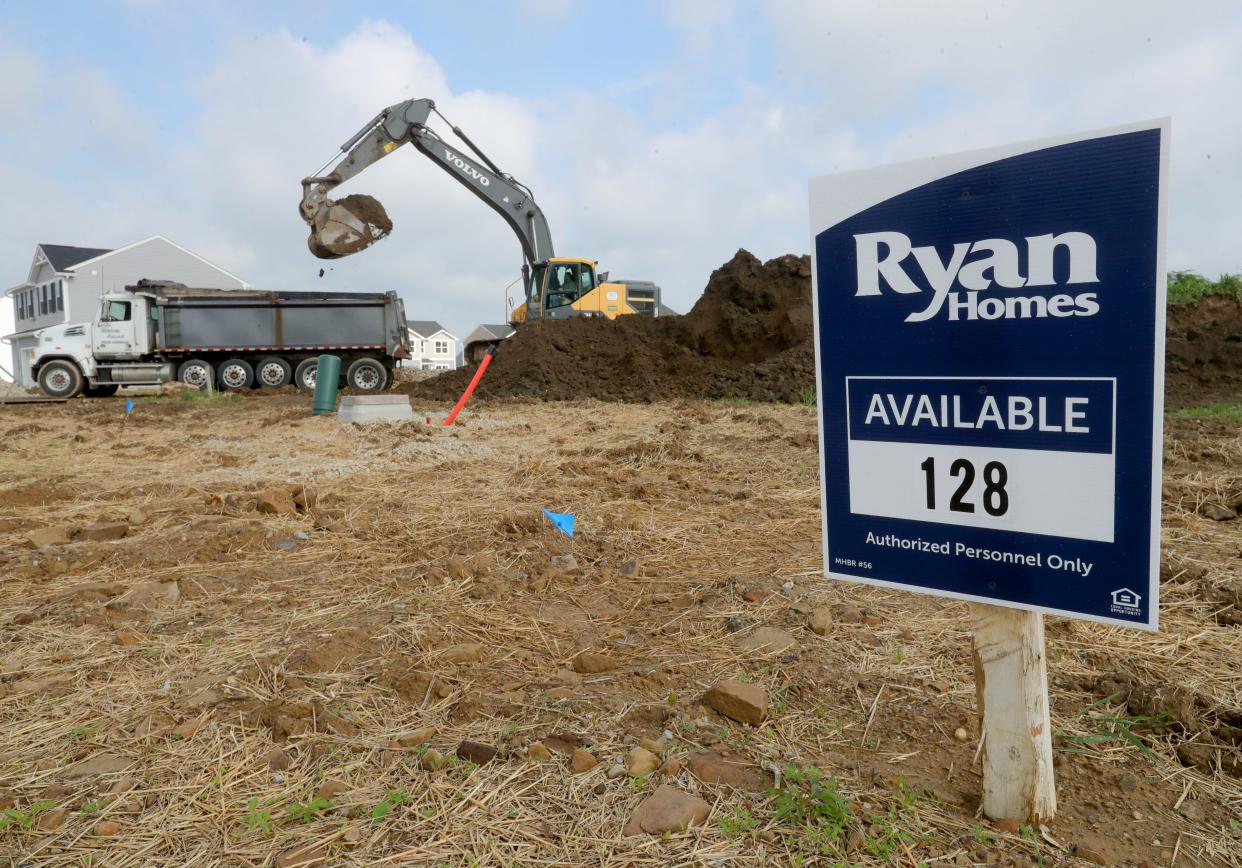 A construction crew works Thursday on a new phase of housing on Himelrigh Boulevard in the East New Haven development in Barberton.