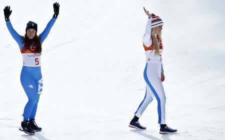 Alpine Skiing - Pyeongchang 2018 Winter Olympics - Women's Downhill - Jeongseon Alpine Centre - Pyeongchang, South Korea - February 21, 2018 - Bronze medallist Lindsey Vonn of the U.S. walks in front of gold medallist Sofia Goggia of Italy during the flower ceremony. REUTERS/Mike Segar