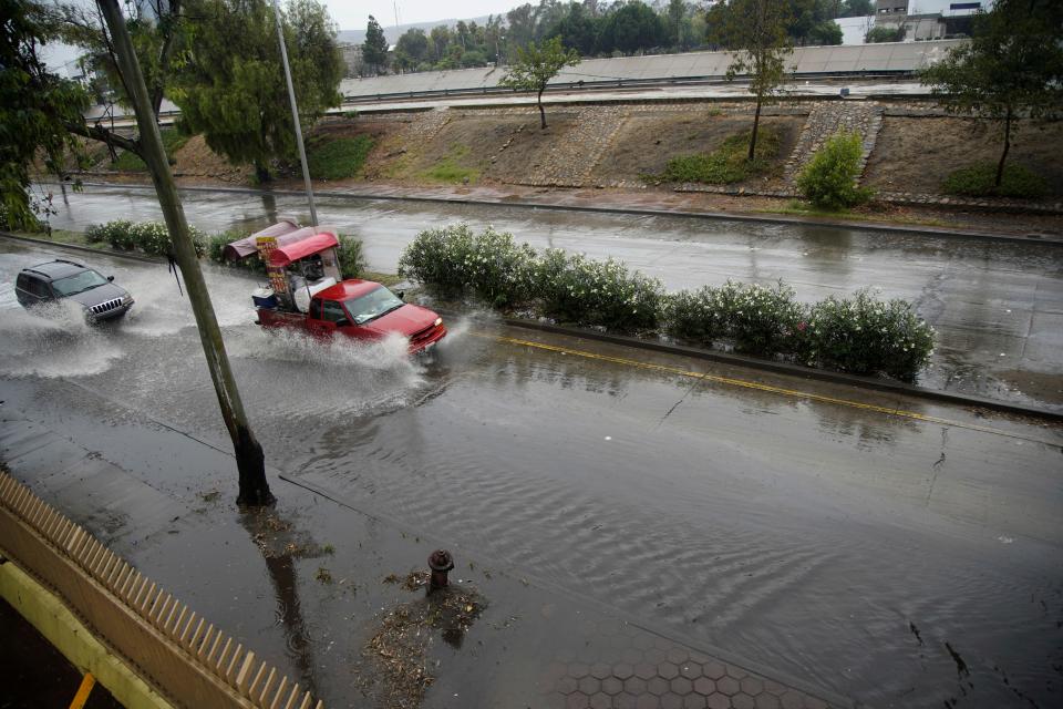 Vehicles make their way through a flooded road in Zona Rio as Tropical Storm Hilary hits the region on Sunday, Aug. 20, 2023, in Tijuana, Baja California. (Alejandro Tamayo/The San Diego Union-Tribune via AP)