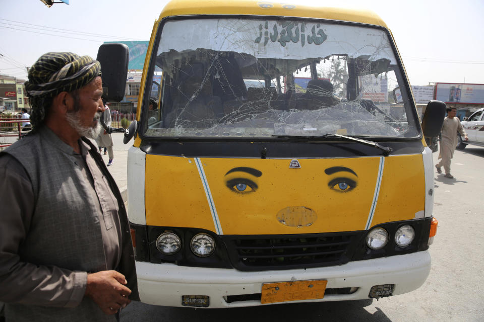 An Afghan man looks at a transport bus damaged by an explosion near the police headquarters in Kabul, Afghanistan, Wednesday, Aug. 7, 2019. A suicide car bomber targeted the police headquarters in a minority Shiite neighborhood in western Kabul on Wednesday, setting off a huge explosion that wounded dozens of people, Afghan officials said. The Taliban claimed responsibility for the bombing. (AP Photo/Rafiq Maqbool)