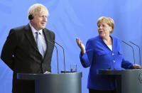 Germany's Chancellor Angela Merkel and British Prime Minister Boris Johnson attend a joint press conference, in Berlin, Wednesday, Aug. 21, 2019. German Chancellor Angela Merkel says she plans to discuss with UK Prime Minister Boris Johnson how Britain's exit from the European Union can be "as frictionless as possible." (Jorg Carstensen/dpa via AP)