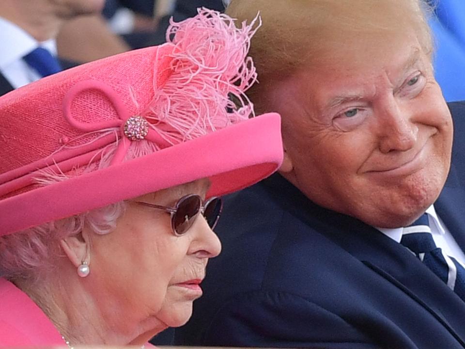 The Queen, seen in sunglasses and wearing a pink hat, sits next to the former president.