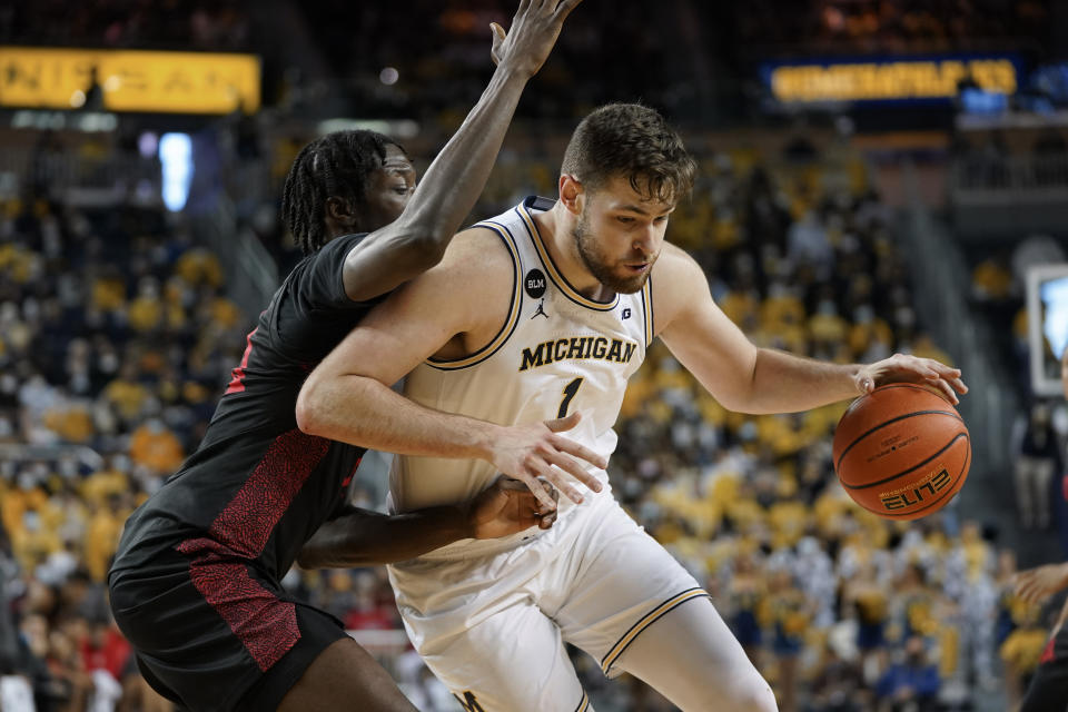 Michigan center Hunter Dickinson (1) drives on San Diego State forward Nathan Mensah (31) in the second half of an NCAA college basketball game in Ann Arbor, Mich., Saturday, Dec. 4, 2021. (AP Photo/Paul Sancya)