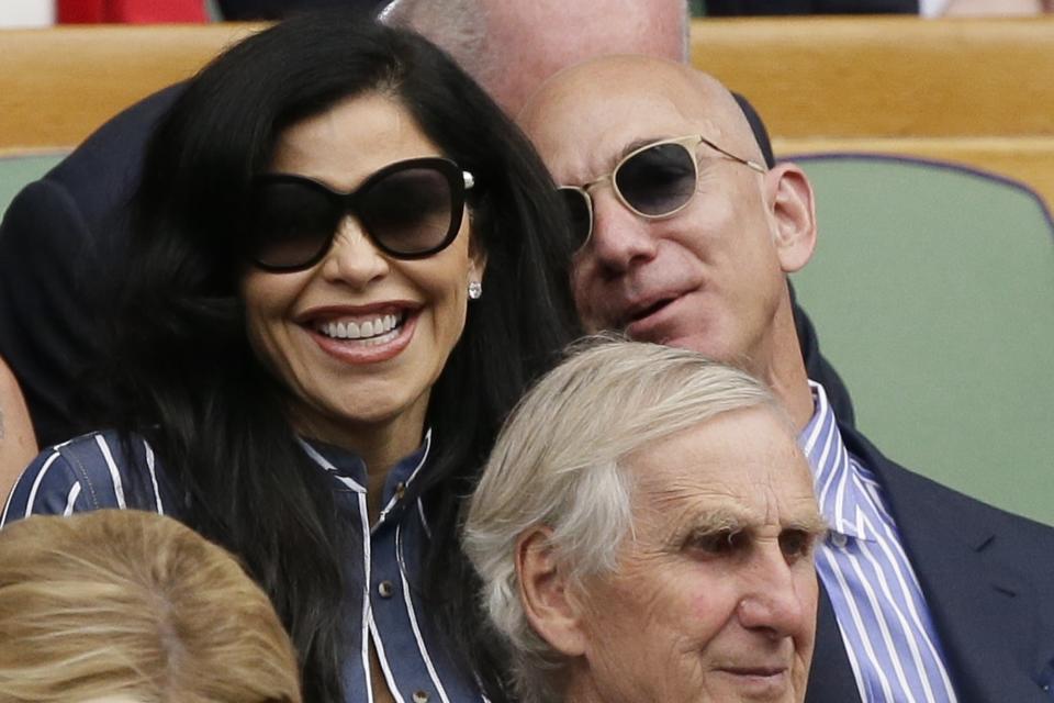 Amazon founder Jeff Bezos and Lauren Sanchez sit in the Royal Box to watch the men's singles final match of the Wimbledon Tennis Championships in London, Sunday, July 14, 2019. (AP Photo/Tim Ireland)