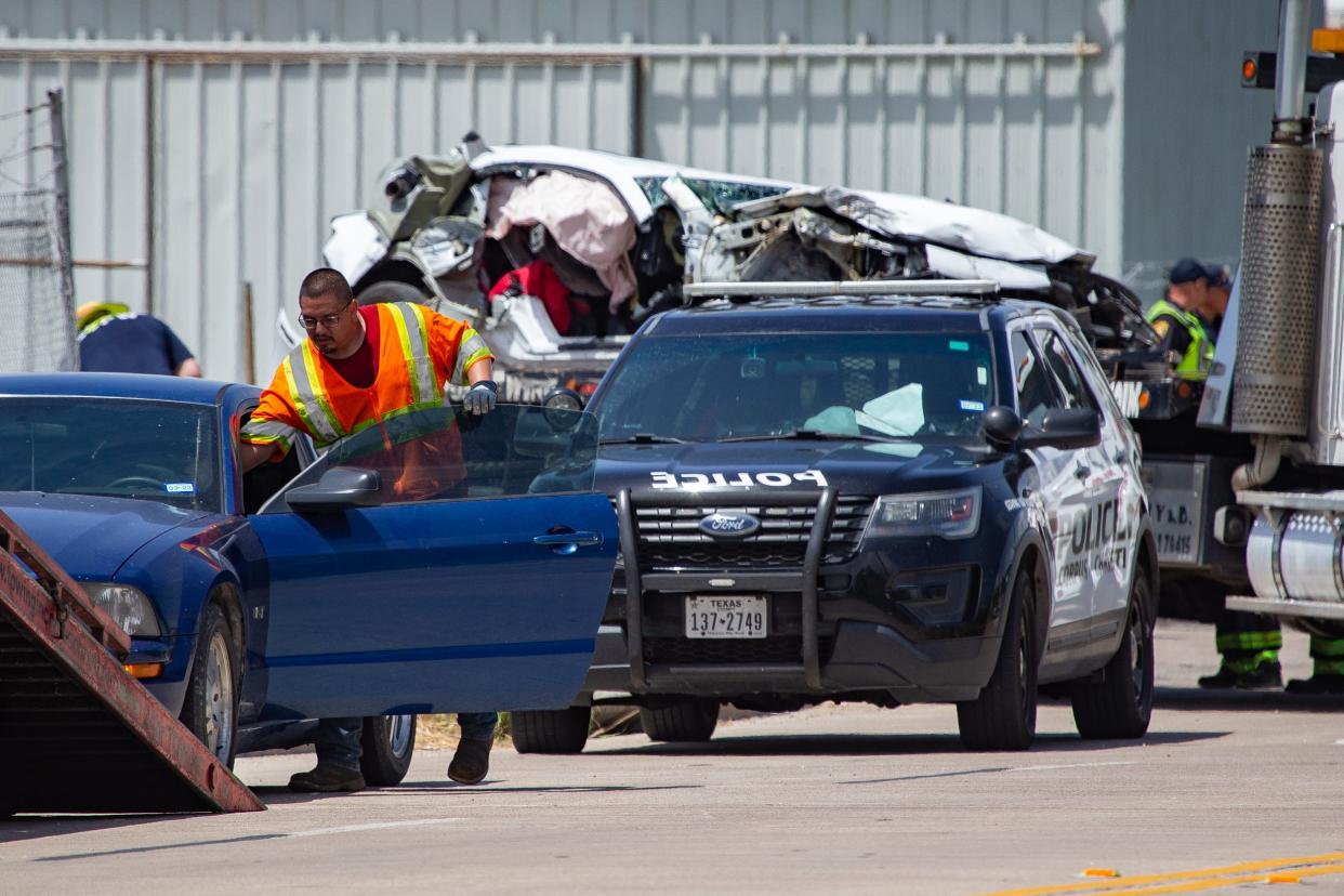 A crew works to load crashed vehicles onto tow trucks at the 2300 block of Port Avenue following a fatal accident on May 31, 2022.