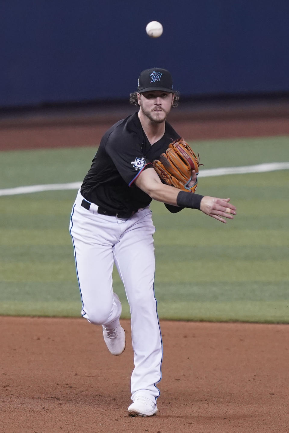 Miami Marlins third baseman Brian Anderson throws to first base on a hit by San Francisco Giants' Austin Slater (13) during the fourth inning of a baseball game, Friday, April 16, 2021, in Miami. (AP Photo/Marta Lavandier)