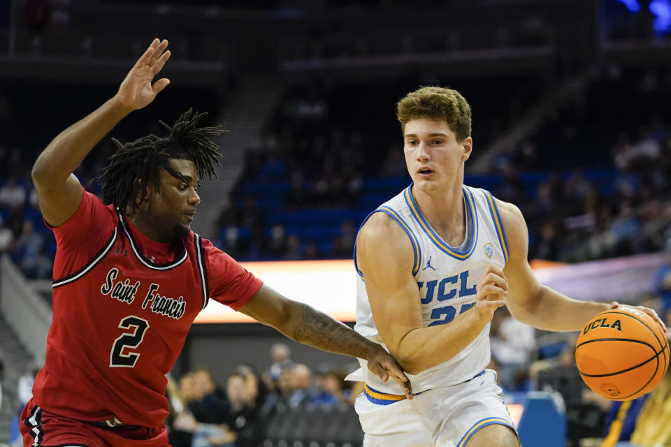 UCLA guard Jan Vide, right, drives as St. Francis guard Aaron Talbert (2) defends during the first half of an NCAA college basketball game, Monday, Nov. 6, 2023, in Los Angeles. (AP Photo/Ryan Sun)