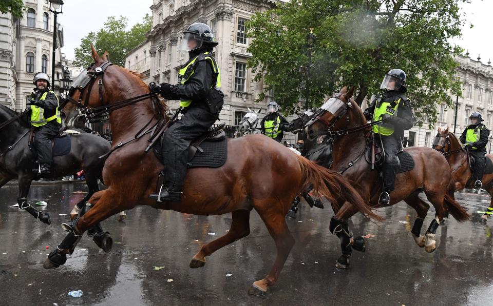 Mounted police officers charge their horses along Whitehall, past the entrance to Downing Street, in an attempt to disperse protestors gathered in central London on June 6, 2020, during a demonstration to show solidarity with the Black Lives Matter movement in the wake of the killing of George Floyd, an unarmed black man who died after a police officer knelt on his neck in Minneapolis. - The United States braced Friday for massive weekend protests against racism and police brutality, as outrage soared over the latest law enforcement abuses against demonstrators that were caught on camera. With protests over last week's police killing of George Floyd, an unarmed black man, surging into a second weekend, President Donald Trump sparked fresh controversy by saying it was a "great day" for Floyd. (Photo by DANIEL LEAL-OLIVAS / AFP) (Photo by DANIEL LEAL-OLIVAS/AFP via Getty Images)