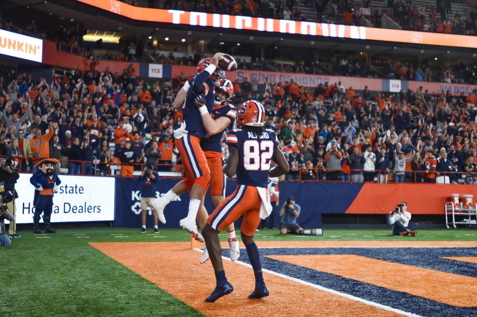 Syracuse quarterback Garrett Shrader (6) celebrates with tight end Maximilian Mang and wide receiver Damien Alford (82) after scoring against Virginia during the first half of an NCAA football game Friday, Sept. 23, 2022, in Syracuse, N.Y. (AP Photo/Adrian Kraus)