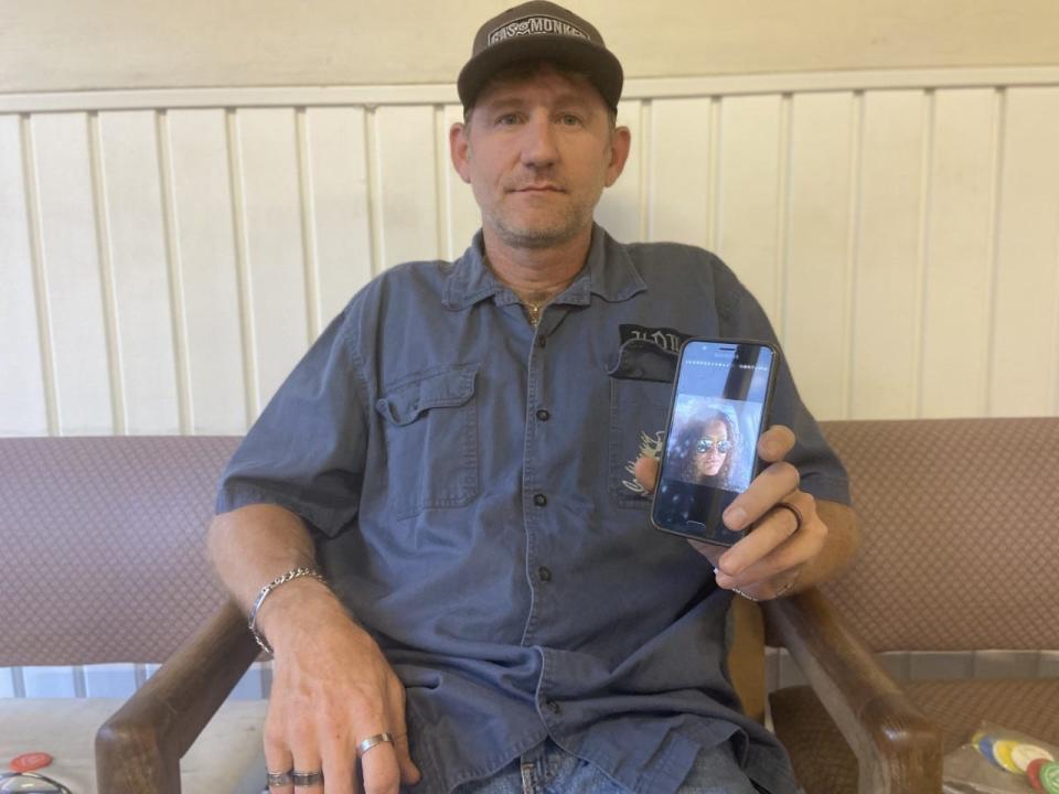 Sean Keyes holds up a picture on his phone of his cousin Brenda Brett who died after an accidental overdose