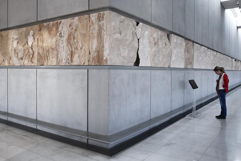 A visitor to the Acropolis Museum in Athens looks at the Parthenon temple frieze, the white parts representing the segments of the frieze on display at the British Museum in London