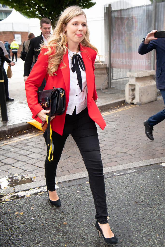 Carrie Johnson arrives at the Conservative Party Conference in Manchester in a red blazer and ribbon-tie blouse, both from Zara. (Getty Images)