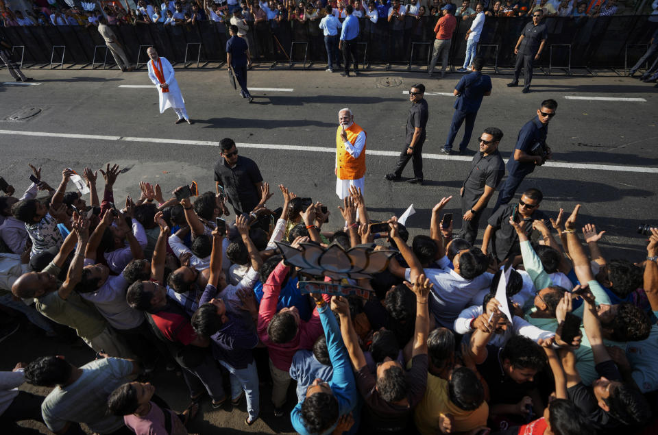 FILE- Indian Prime Minister Narendra Modi, center, shows the indelible ink mark on his index finger after casting his vote during the third phase of general elections, in Ahmedabad, Gujarat, India, Tuesday, May 7, 2024. Indian Home Minister Amit Shah, wearing saffron shawl is behind left. (AP Photo/Ajit Solanki, File)