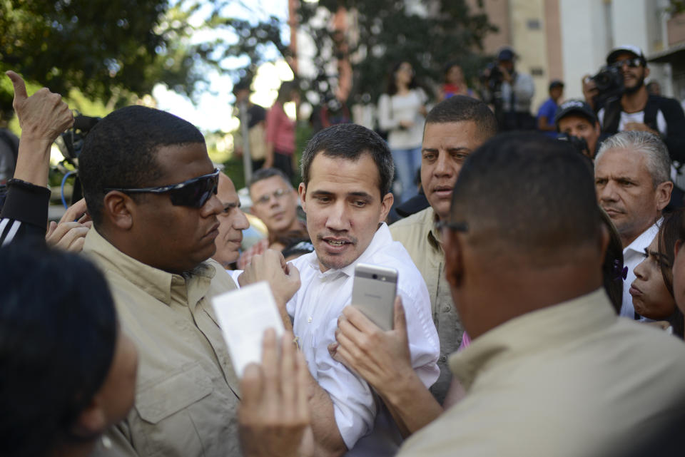 Bodyguards escort opposition leader Juan Guaido away from an outdoor event where he spoke to supporters in the Montalban neighborhood of Caracas, Venezuela, Saturday, Jan. 11, 2020. Venezuelans are deciding whether or not to heed Guaido's call for a new round of protests amid skepticism that he can still mobilize large numbers, and an estimated 4.5 million people have fled the country. (AP Photo/Matias Delacroix)