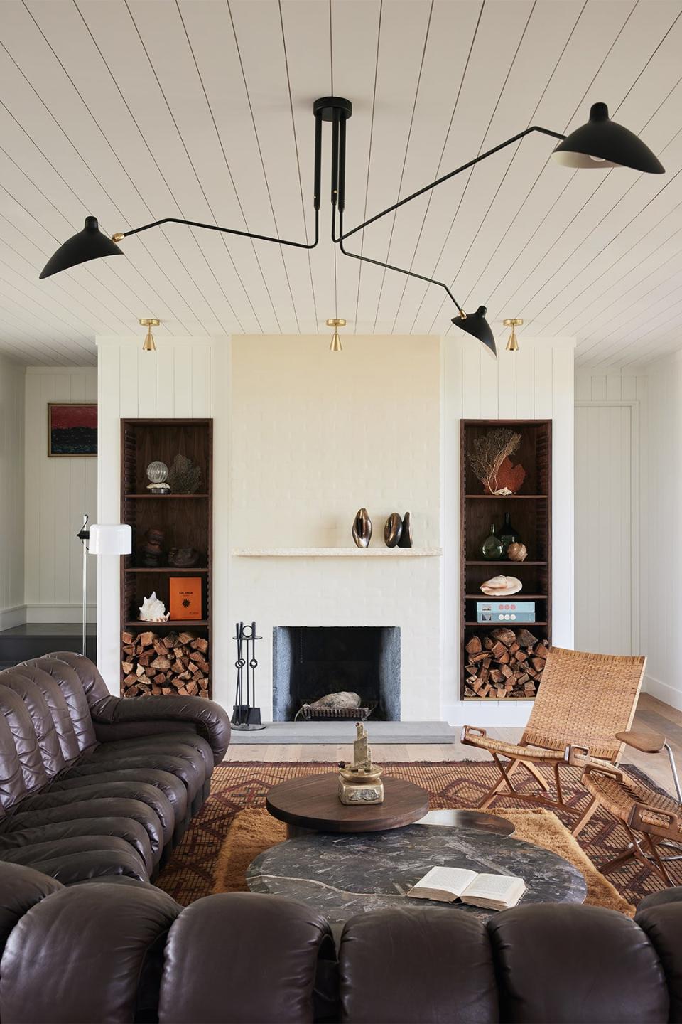 Living room with curved brown sofa and fireplace