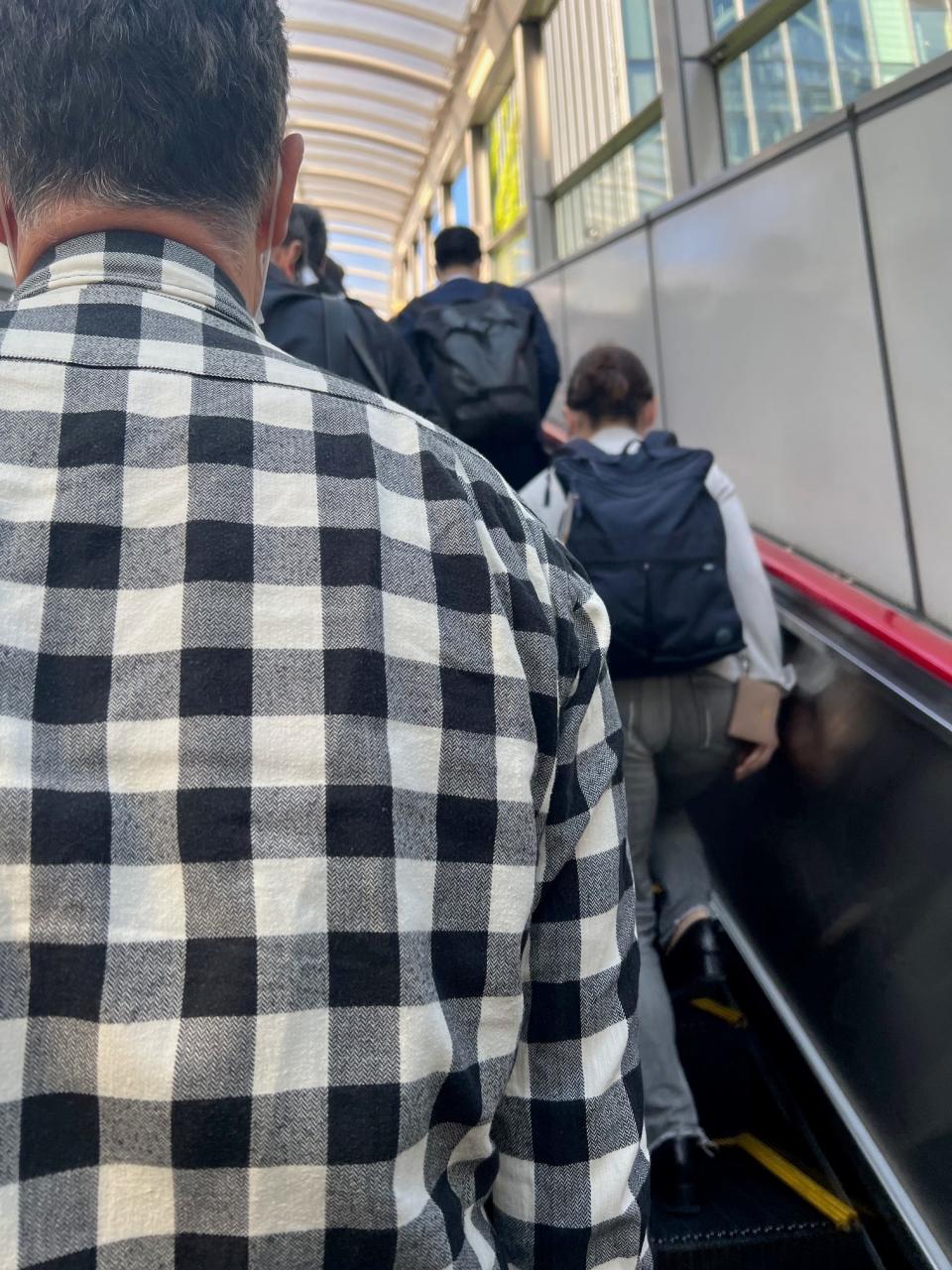 Pedestrians stand to the left on escalators, allowing others to walk along the right.