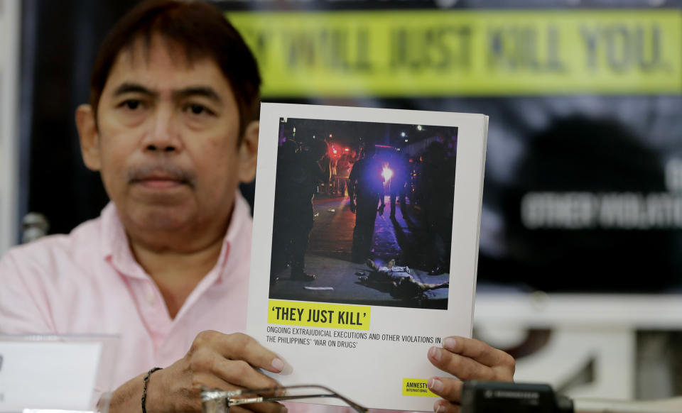 Butch Olano, Amnesty International Section Director in the Philippines, holds a copy of the Amnesty's report during a news conference, Monday, July 8, 2019, in Manila, Philippines. Amnesty International has urgently called for international pressure and an immediate U.N. investigation to help end what it says are possible crimes against humanity in the Philippine president's bloody anti-drug crackdown. (AP Photo/Bullit Marquez)