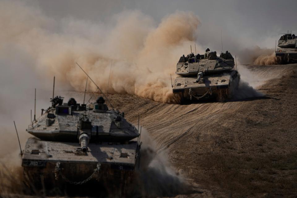 Israeli tanks head towards the Gaza Strip border in southern Israel (AP)