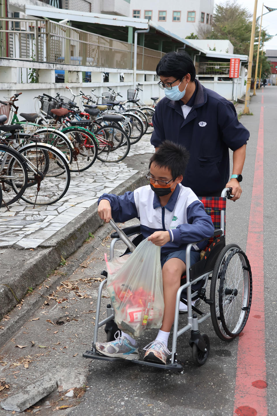 老師協助同學一起清理街道,即使行動不便,仍然堅持全程參與活動,沿著街道撿拾各項垃圾。